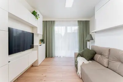 a living room with a couch and a flat screen tv at Bohomolca Chic Studio with Garden by BookingHost in Kraków