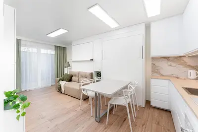 a kitchen and living room with a table and chairs at Bohomolca Chic Studio with Garden by BookingHost in Kraków
