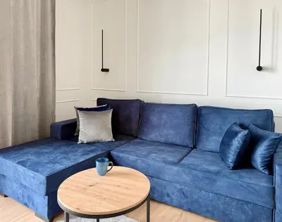 a blue couch in a living room with a table at Modern Blue Apartment in Kraków