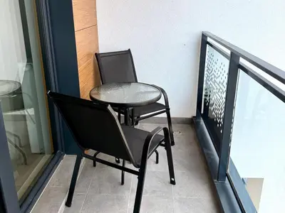 two chairs and a table on a balcony at Modern Blue Apartment in Kraków