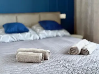 two towels on a bed with two pillows at Modern Blue Apartment in Kraków
