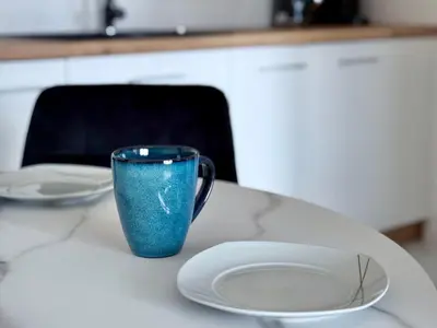 a blue cup sitting on a counter next to a plate at Modern Blue Apartment in Kraków