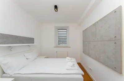 a bedroom with a bed and a dining room at Ariańska Comfort Apartment by BookingHost in Kraków