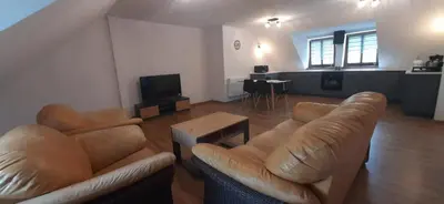 a living room with two leather couches and a television at Apartamenty Kraków-Bielany in Kraków