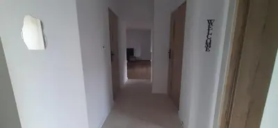 a hallway with white walls and a hallway with doors at Apartamenty Kraków-Bielany in Kraków