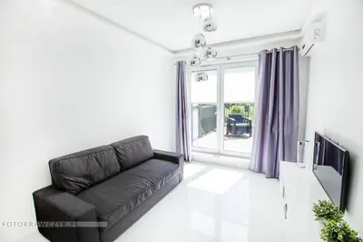 a living room with a couch and a tv at Apartament Nadwiślańska in Kraków