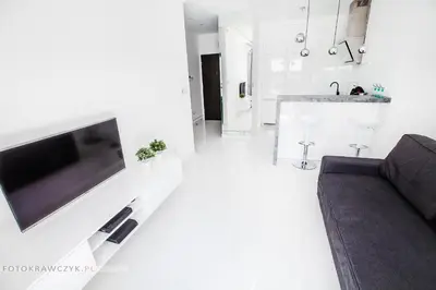 a living room with a couch and a tv on a wall at Apartament Nadwiślańska in Kraków