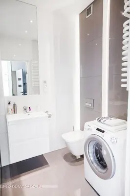 a white bathroom with a washing machine in it at Apartament Nadwiślańska in Kraków