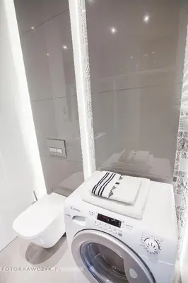 a white washing machine in a bathroom with a toilet at Apartament Nadwiślańska in Kraków