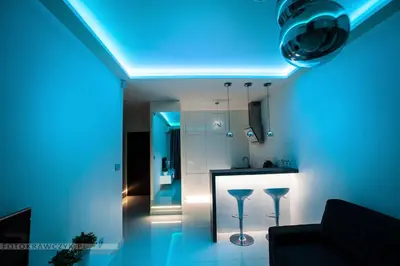 a living room with a blue light on the ceiling at Apartament Nadwiślańska in Kraków