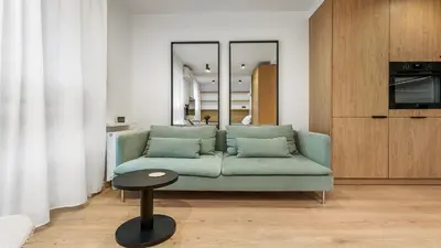 a living room with a green couch and a table at Kluczborska Chic Studio by BookingHost in Kraków