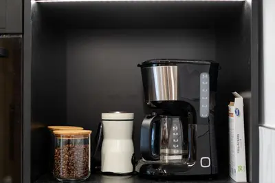 a black coffeemaker sitting on a kitchen counter at Kluczborska Chic Studio by BookingHost in Kraków