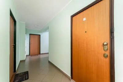 a hallway with a wooden door and a tile floor at Kluczborska Chic Studio by BookingHost in Kraków