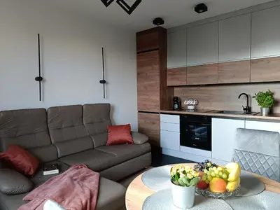 a living room with a couch and a table with a bowl of fruit at Cracowapart Sunny Point in Kraków