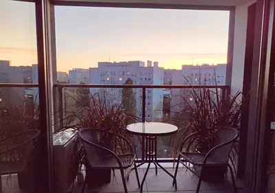 a balcony with a table and chairs and a view of a city at Cracowapart Sunny Point in Kraków