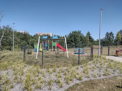 a playground with a swing set in a field at Cracowapart Sunny Point in Kraków
