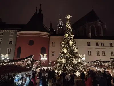 a christmas tree in front of a crowd of people at Cracowapart Sunny Point in Kraków