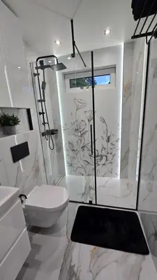 a white bathroom with a toilet and a shower at Leśna Enklawa pod Wielką Górą in Pisarzowa