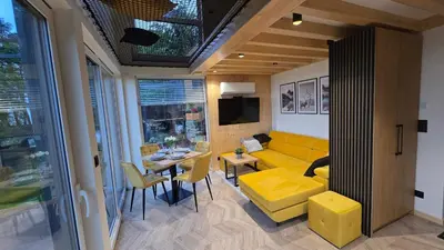 a living room with a yellow couch and a table at Leśna Enklawa pod Wielką Górą in Pisarzowa