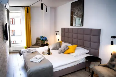 a bedroom with a large white bed with yellow pillows at Susan Apartaments Kraków Kazimierz in Kraków