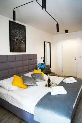 a bedroom with a large white bed with yellow pillows at Susan Apartaments Kraków Kazimierz in Kraków