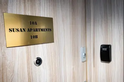 a sign on a wooden door with a sign on it at Susan Apartaments Kraków Kazimierz in Kraków