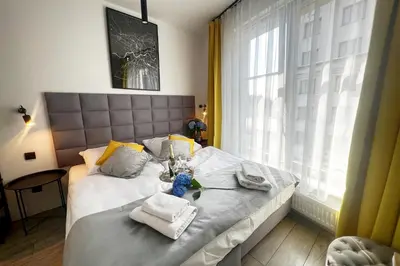 a bedroom with a bed with towels and a window at Susan Apartaments Kraków Kazimierz in Kraków