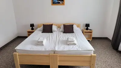 a bed in a room with two nightstands and a bed with white sheets at Noclegi Pod Lyskami in Nowy Targ