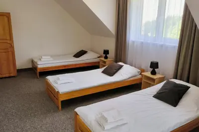 a room with two beds and a window at Noclegi Pod Lyskami in Nowy Targ