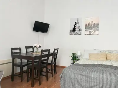 a living room with a table and a chair at Smart Studio for 3 guests 8 min to Main Square in Kraków