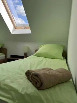 a bedroom with a bed with a towel on it at Bądź blisko in Jurków