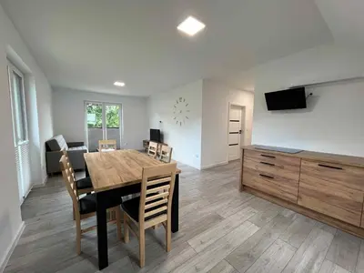 a living room with a dining room table and a couch at Bądź blisko in Jurków