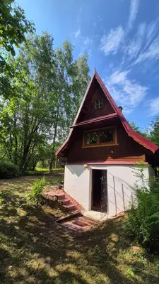 a small house with a red roof and a window at Chatka Cicho-Sza in Lanckorona