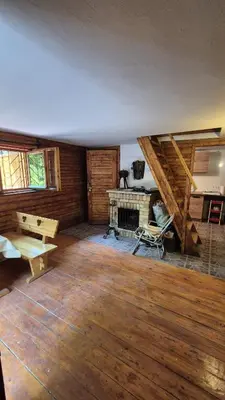 a large room with a fireplace and wooden floors at Chatka Cicho-Sza in Lanckorona