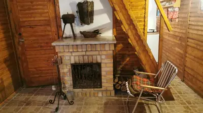 a living room with a fireplace and a chair at Chatka Cicho-Sza in Lanckorona