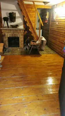 a living room with a fireplace and a chair at Chatka Cicho-Sza in Lanckorona
