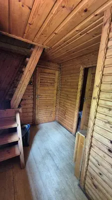 an attic room with wooden walls and wooden ceilings at Chatka Cicho-Sza in Lanckorona
