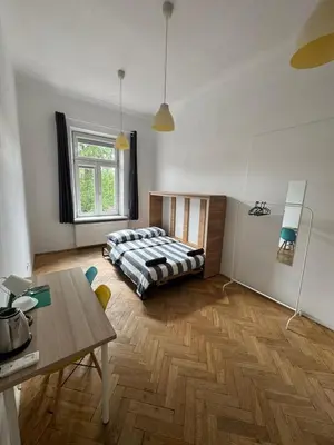 a bedroom with a bed and a wooden floor at Fantastic-Inn Kraków - Krasińskiego in Kraków