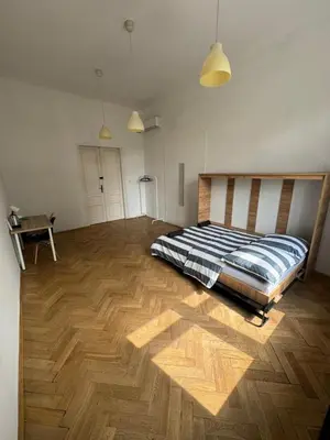 a bedroom with a bed on a wooden floor at Fantastic-Inn Kraków - Krasińskiego in Kraków