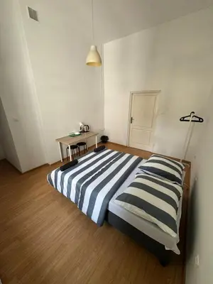 a bedroom with a striped bed and a table at Fantastic-Inn Kraków - Krasińskiego in Kraków