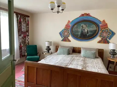 a bedroom with a bed with a painting on the wall at Podgórska 7 in Lanckorona