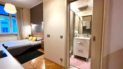 a small room with a bed and a mirror at Studio in Kraków Center in Kraków