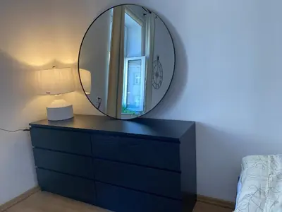 a mirror on top of a dresser in a bedroom at Luna Rooms in Kraków