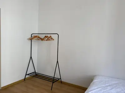 a shelf with shoes on it next to a bed at Luna Rooms in Kraków