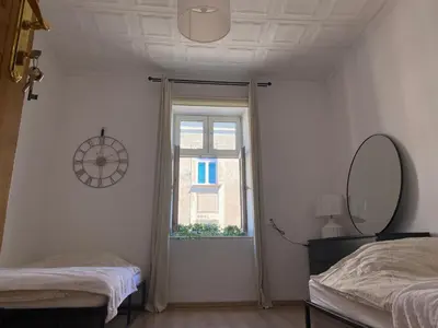 a bedroom with two beds and a mirror and a window at Luna Rooms in Kraków