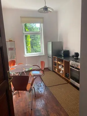 a kitchen with a table and chairs and a window at Luna Rooms in Kraków