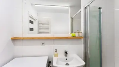 a bathroom with a toilet and a sink and a mirror at Krasińskiego Comfort Studio by BookingHost in Kraków