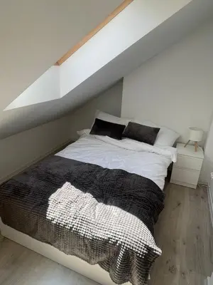 a bedroom with a large bed with white sheets and black pillows at Old Town Escape in Kraków