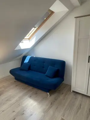 a blue couch in a living room with a skylight at Old Town Escape in Kraków