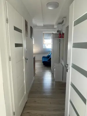 a room with a hallway with white doors and wood floors at Old Town Escape in Kraków